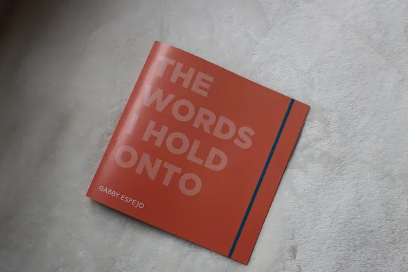 Orange booklet cover reading The Words I Hold Onto