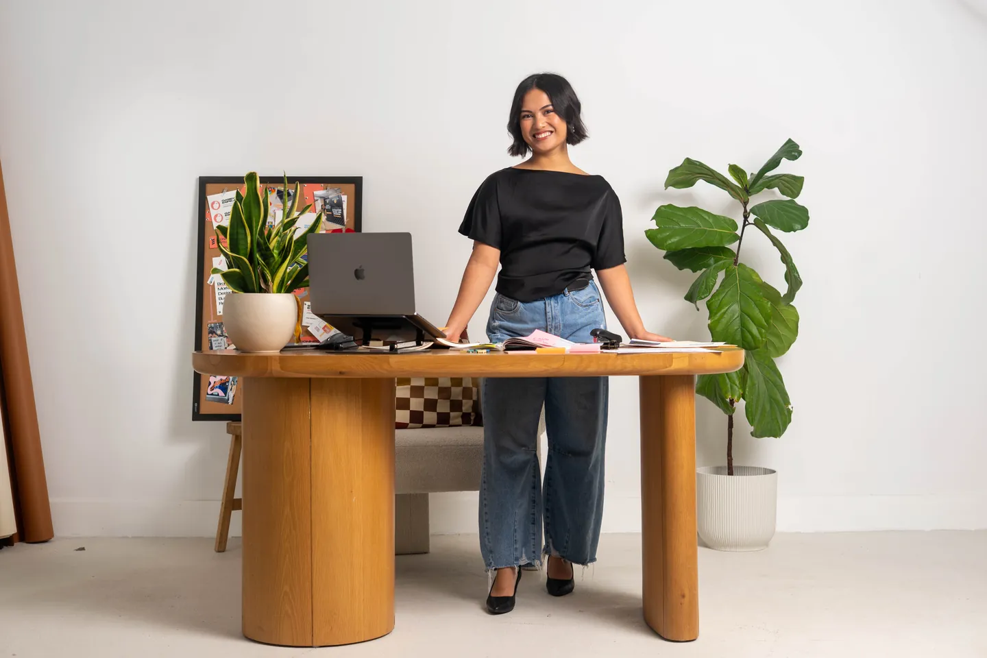 Gabby Espejo standing at a wooden desk in her studio