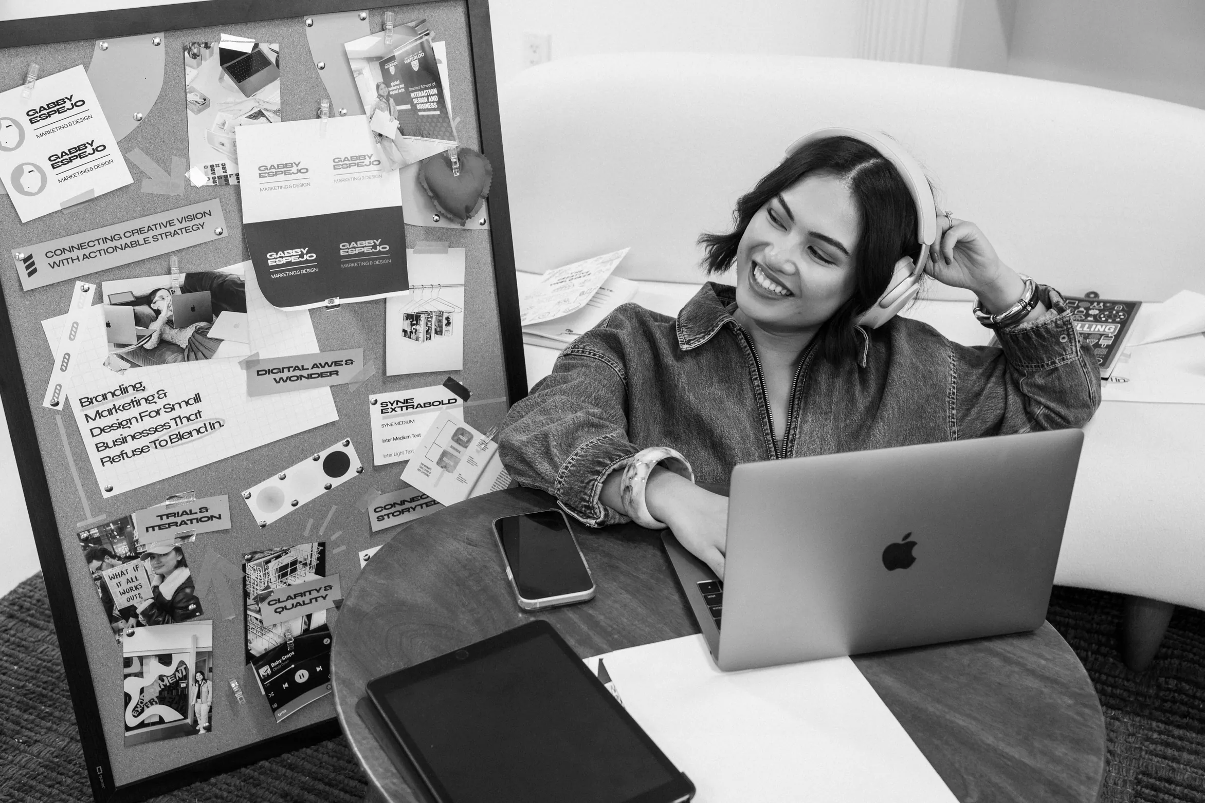 Gabby Espejo smiling with headphones on beside a pinboard of brand work