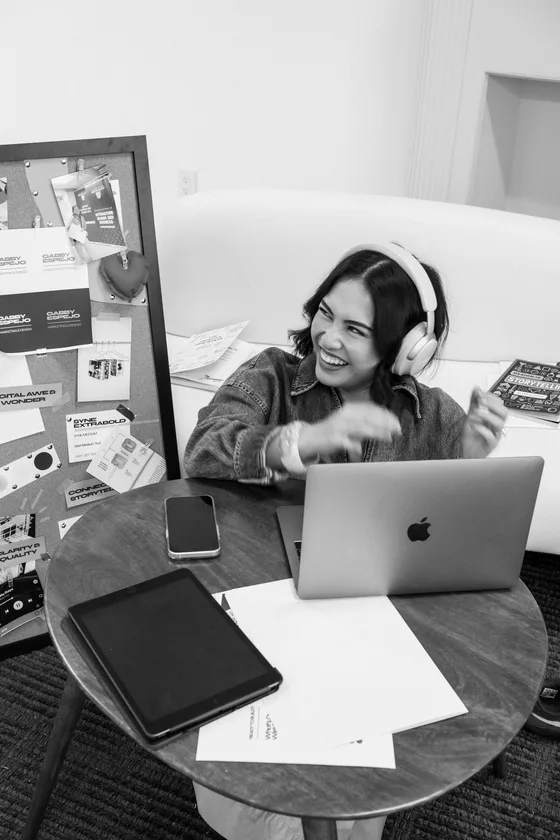 Gabby Espejo laughing at her desk with headphones on