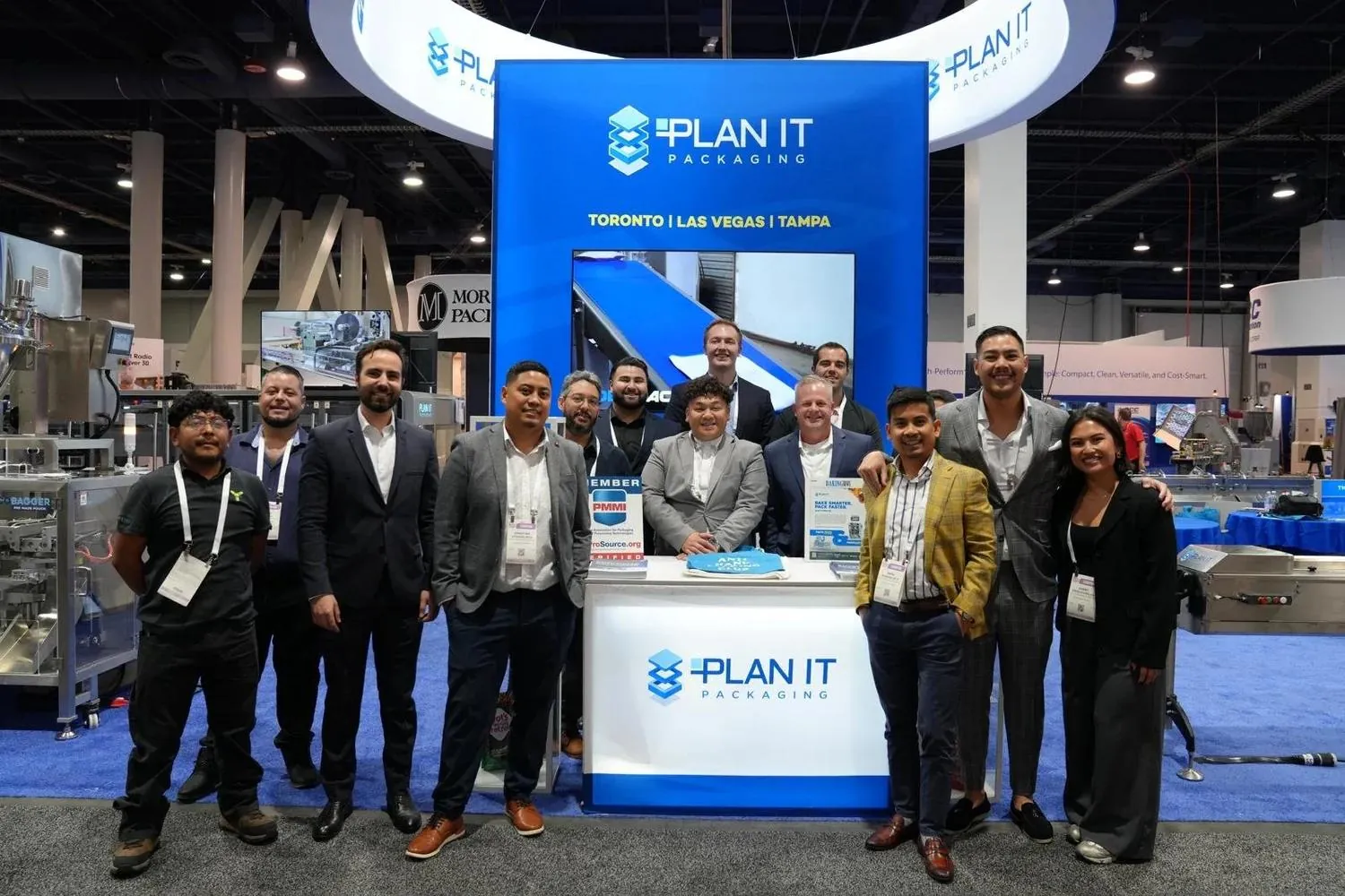 The PLAN IT team standing together at their trade show booth