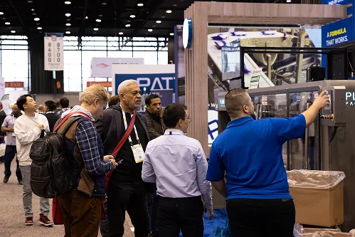 Visitors crowding the PLAN IT booth on the show floor